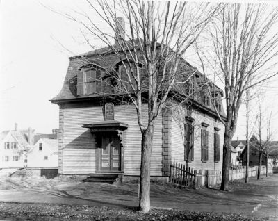 School Street Library 2
Thomas Goodall paid for the construction of this building in 1878 with the intention that it would be used as a library. However the people of Sanford showed little interest for a library at that time, so it was used by various fraternal orders as a meeting place. It finally did become the town library on December 31, 1898 and served that purpose until 1937.

The building was on School Street where the Back Street Grill parking lot is today. The white house with the decorative gable trim (right background) still stands at 17 Bodwell Street.
